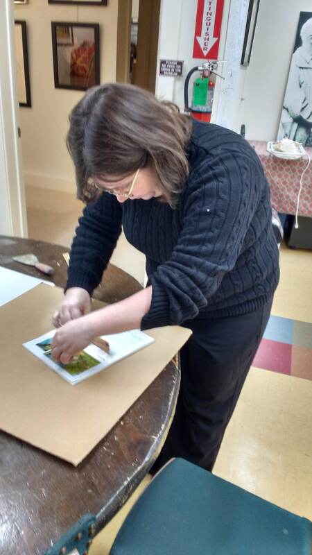 Once the text is sprayed glued we're now smoothing out the bubbles.